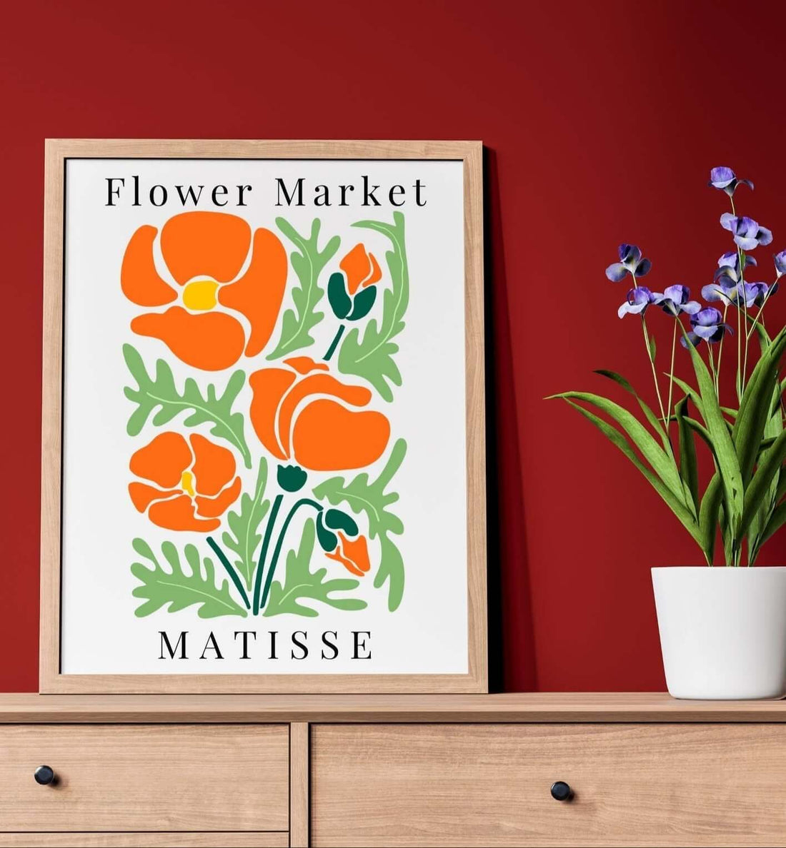 Henri Matisse art influence: vibrant flower market print, showcasing bold colors and forms, on a wooden sideboard with a plant.