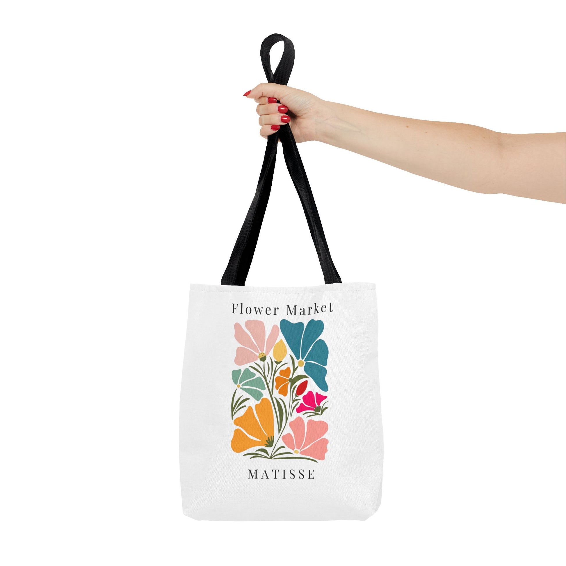 Woman holding Henri Matisse tote bag with artistic floral design and black handles, perfect for art lovers and daily use.