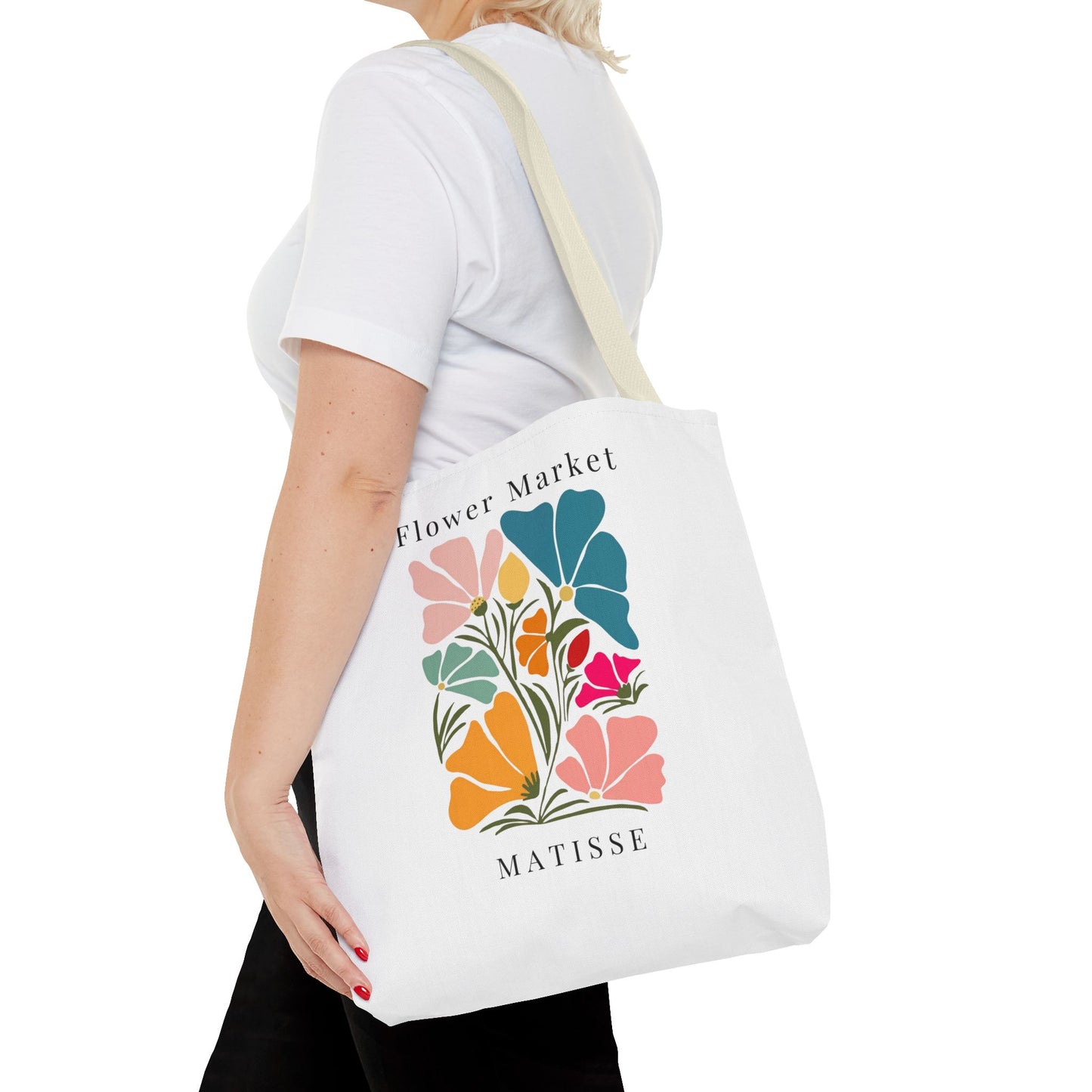 Woman carrying Henri Matisse tote bag with vibrant floral design, showcasing artistic flair and elegance.