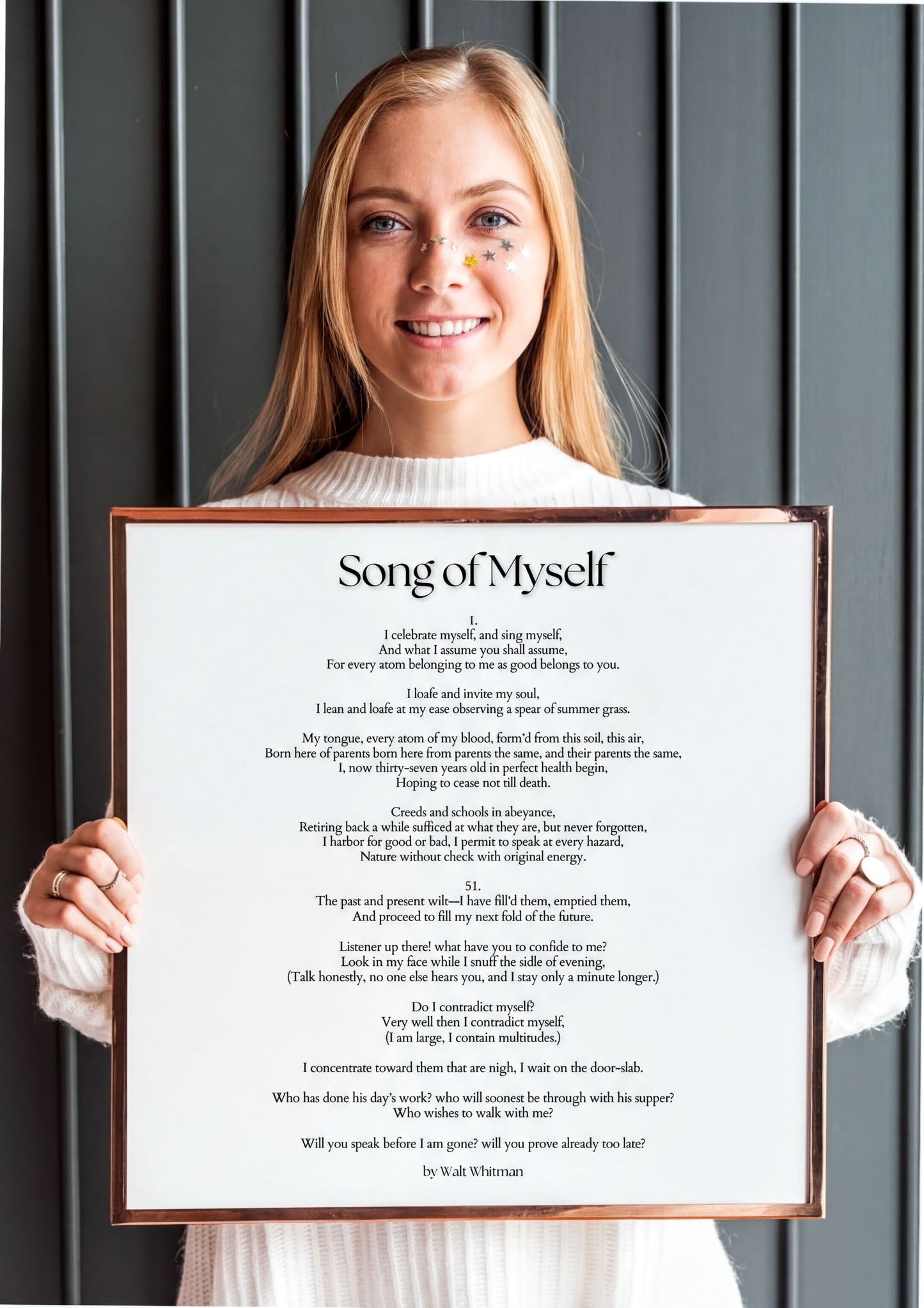 Woman holding a framed Song of Myself Print featuring Walt Whitman's inspirational poetry in elegant typography.
