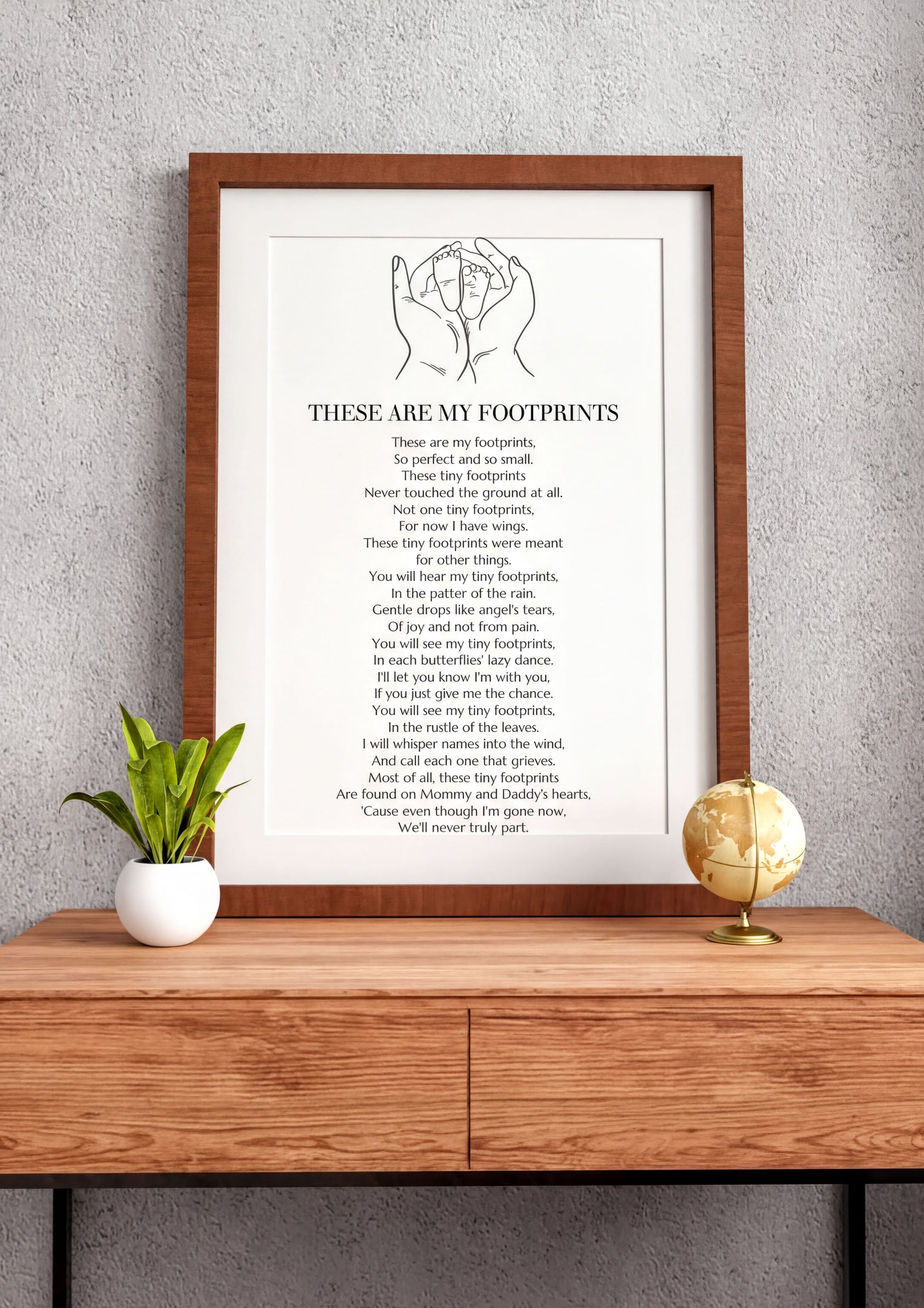 These Are My Footprints Poem Wall Art framed on a wooden table with plant and globe decor