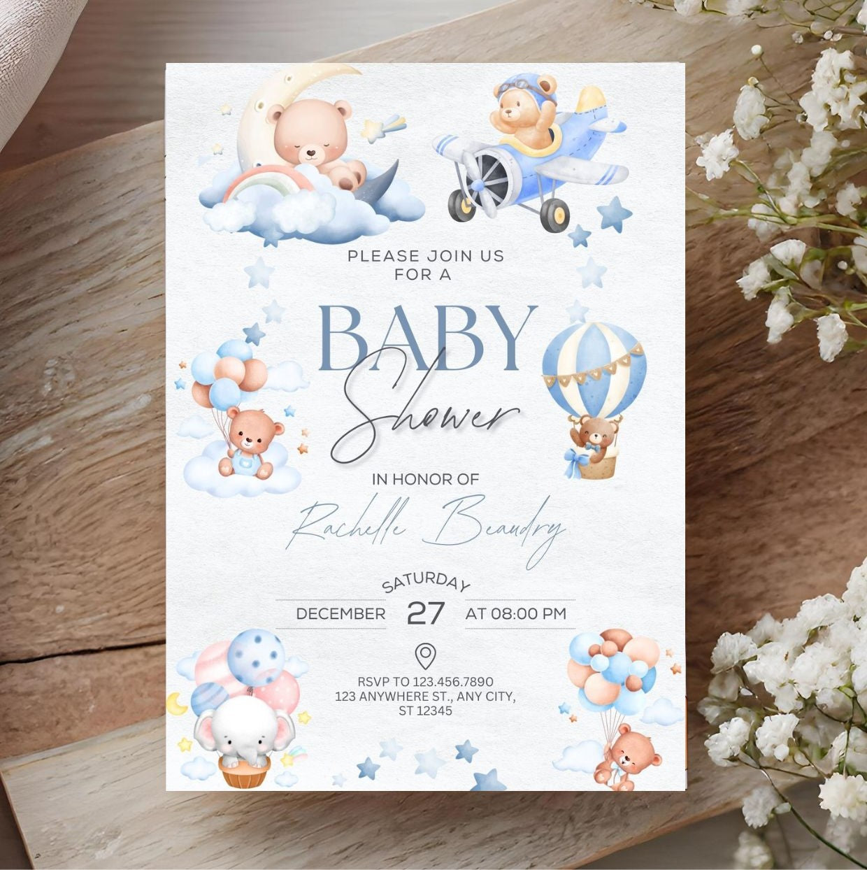 Cute baby shower invitation with teddy bears, clouds, and balloons design on a rustic wooden background, including floral accents.