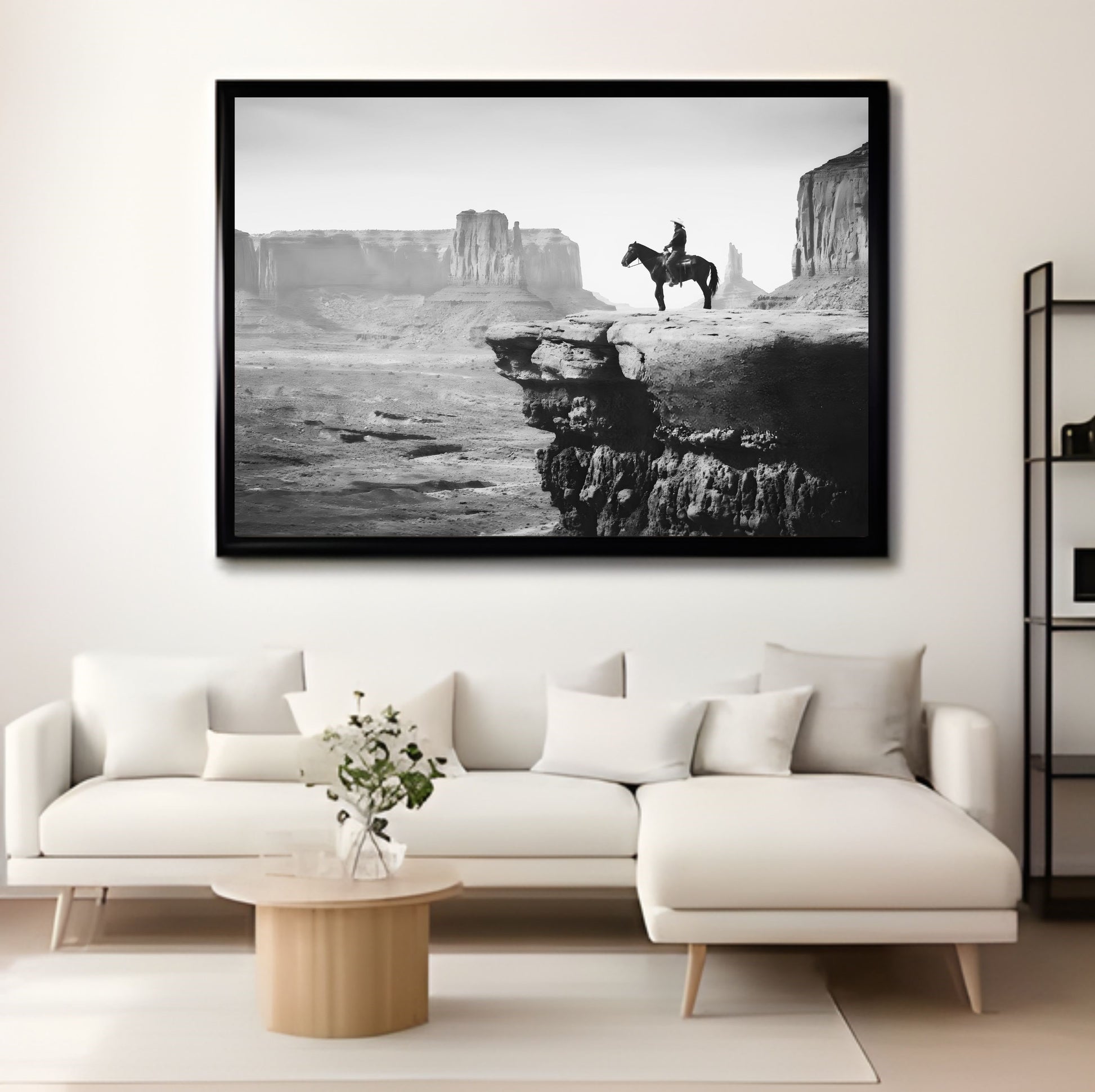Black and white Western Wall Art Print of cowboy on horse in desert landscape above modern sofa